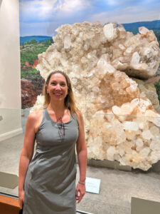 Janae standing with large  gemstones